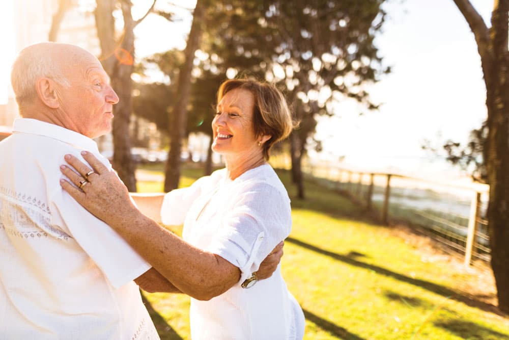 Charter Senior Living of Paducah Residents dressed all in white smiling and dancing together on community grounds