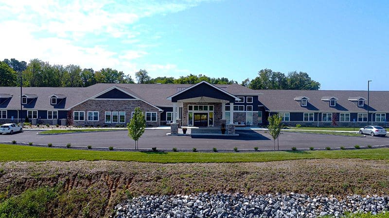 Front exterior view of Charter Senior Living of Paducah, KY, showcasing its welcoming entrance, landscaped grounds, and modern architectural design.