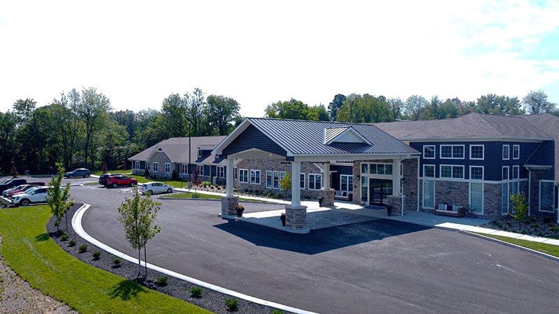 Street-level view of the main entrance at Charter Senior Living of Paducah, KY, with drive-up access, landscaped grounds, and welcoming architecture.