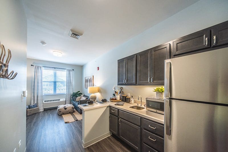 Modern senior living apartment at Charter Senior Living of Paducah, KY, featuring a full kitchen, stainless steel appliances, and a bright, comfortable living area.