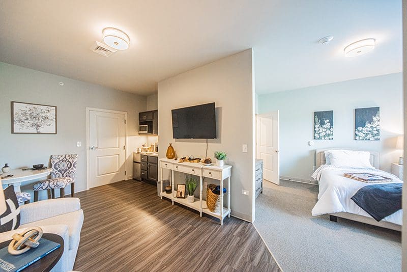 Spacious senior living apartment at Charter Senior Living of Paducah, KY, featuring a cozy living area, kitchenette, and private bedroom for comfort and independence.
