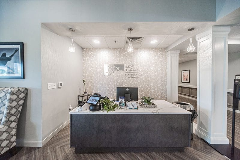 Reception desk at Charter Senior Living of Paducah, KY with modern lighting and welcoming décor