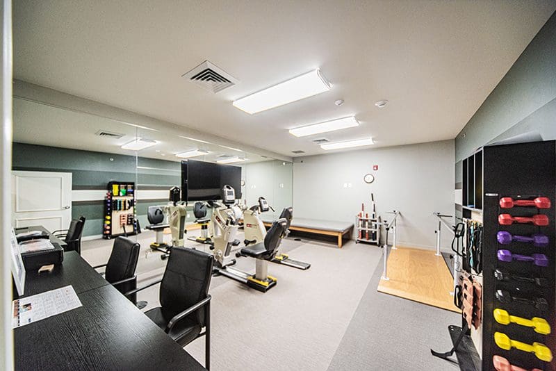 Fitness and wellness room with exercise equipment and free weights at Charter Senior Living of Paducah