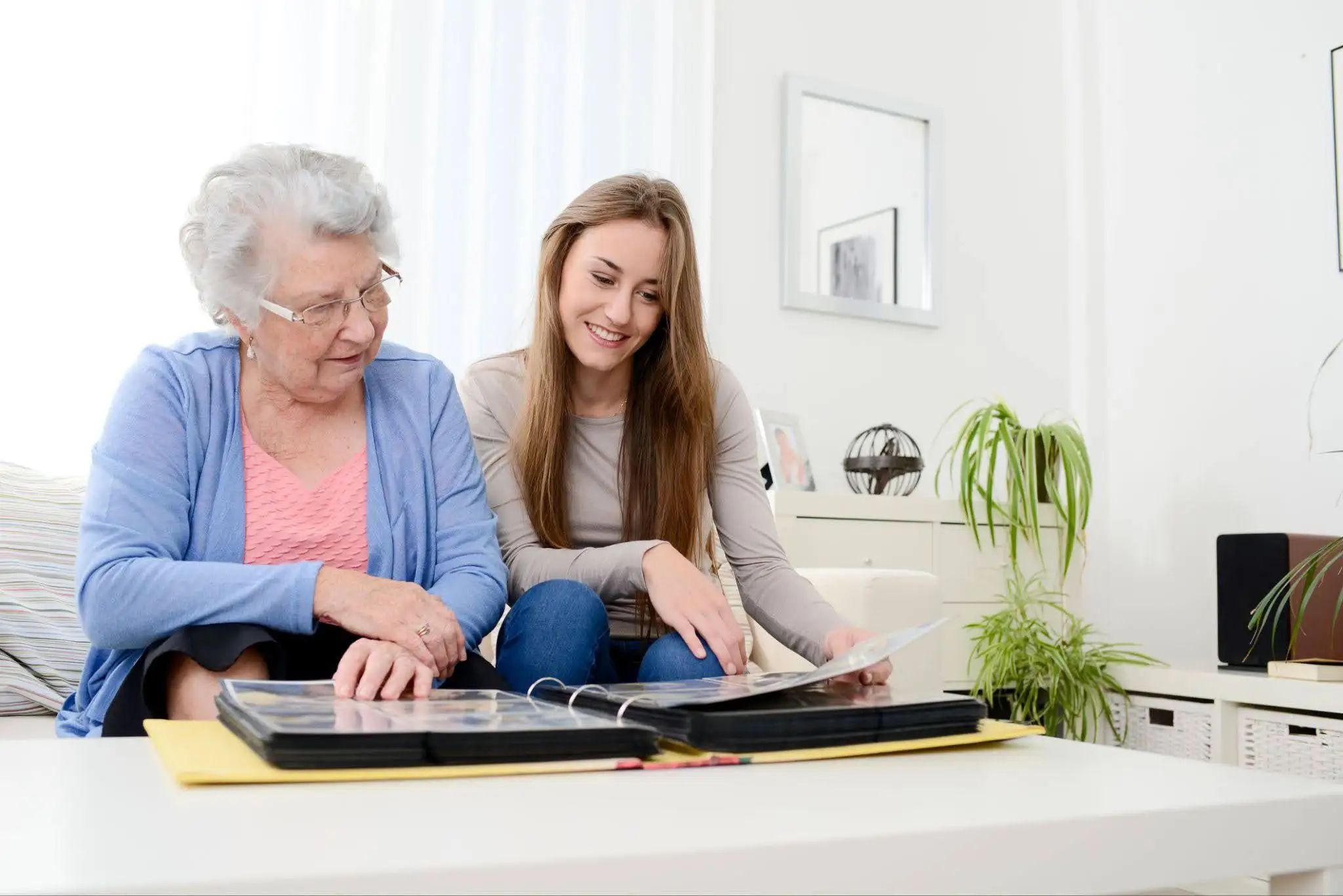 Charter Parent with Dementia Blog Featured Image Senior woman looking through a photo album with her adult daughter